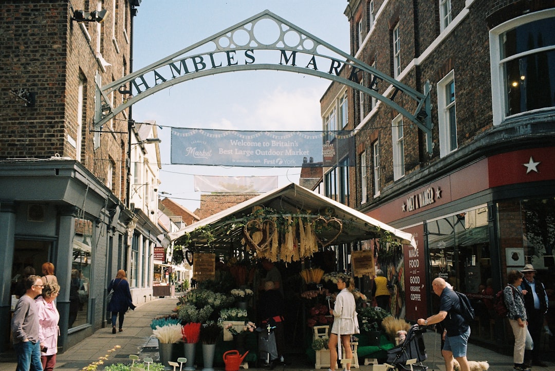 a group of people standing outside of a farmers market
